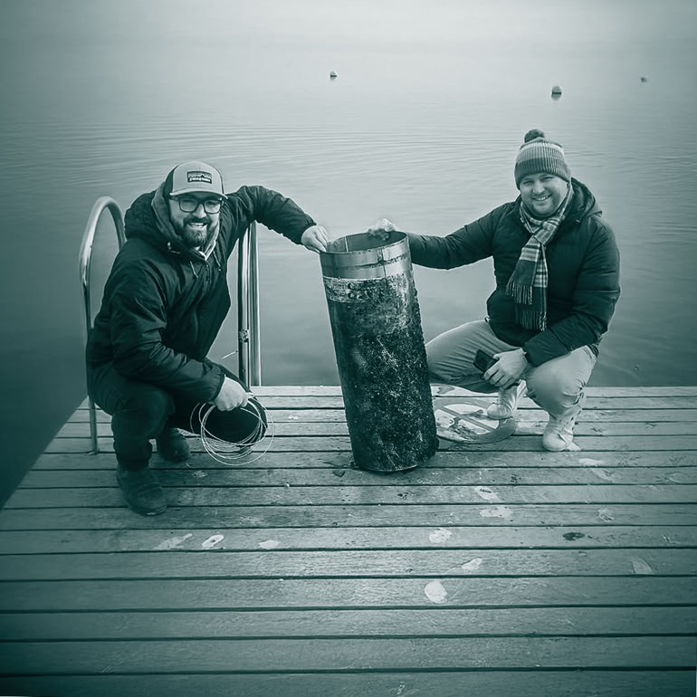 Maxime Rothen et Gaëtan Ruprecht tenant une crépine colonisée par la moule quagga